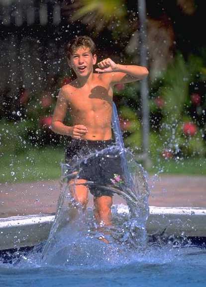 Niño jugando en el agua de una piscina.